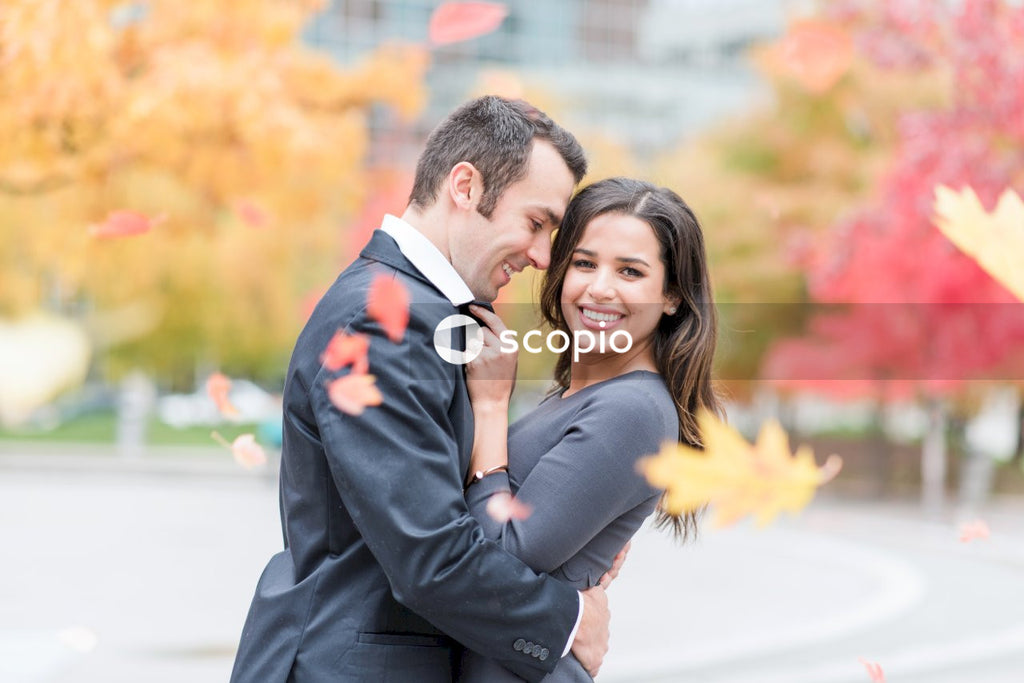 Man in black suit hugging woman in black dress