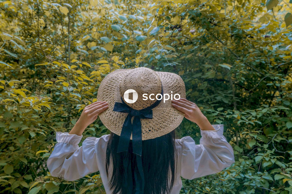 Back view of woman wearing sunhat standing in the woods