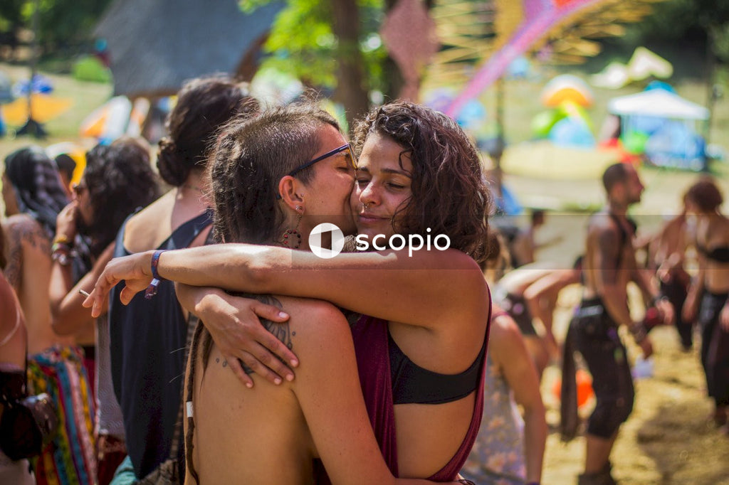 Woman in black and red tank top hugging woman in black tank top