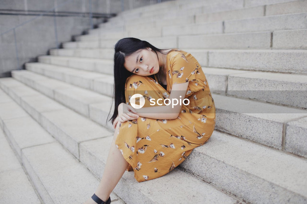 Woman in orange dress sitting on stairs