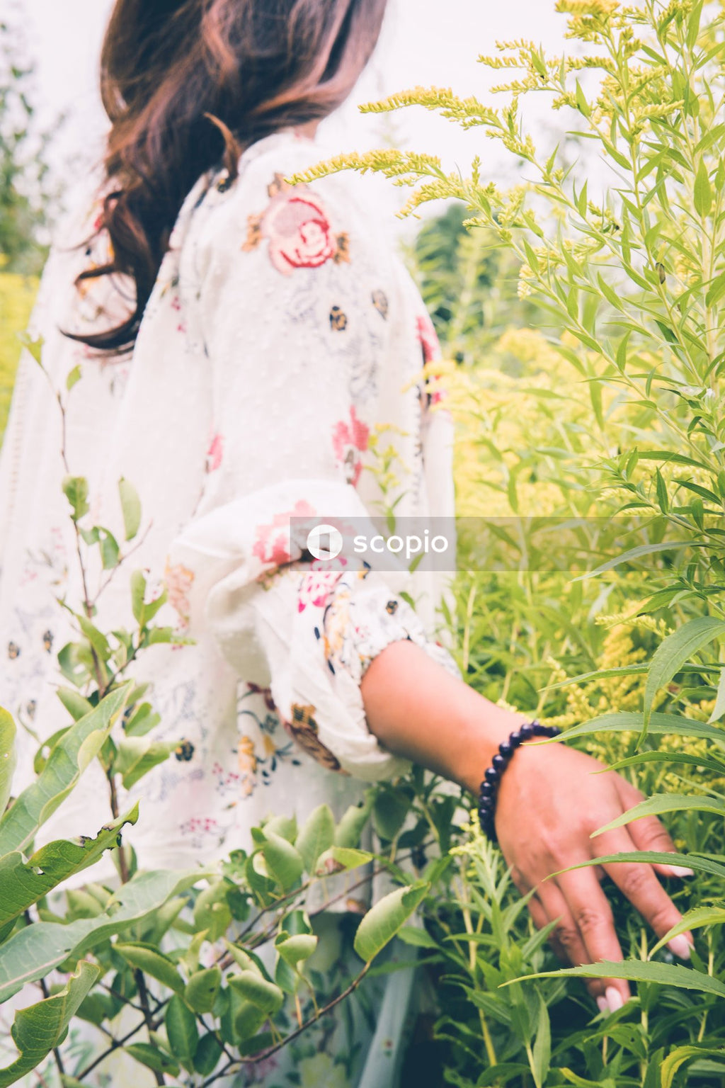 Woman in floral dress standing on green grass field