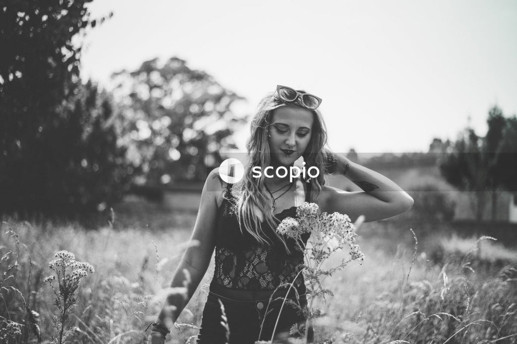 Grayscale photo of woman in black tank top holding bouquet of flowers