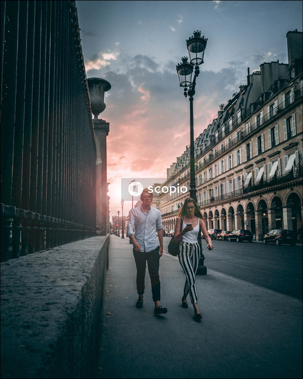 Couple walking on sidewalk during sunset