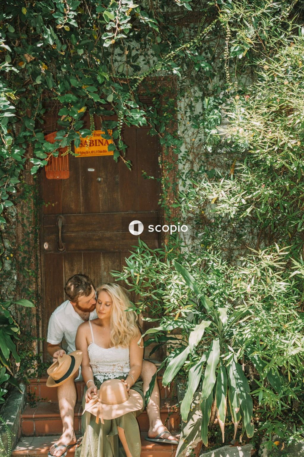 Man and woman sitting on doorstep of house hugging