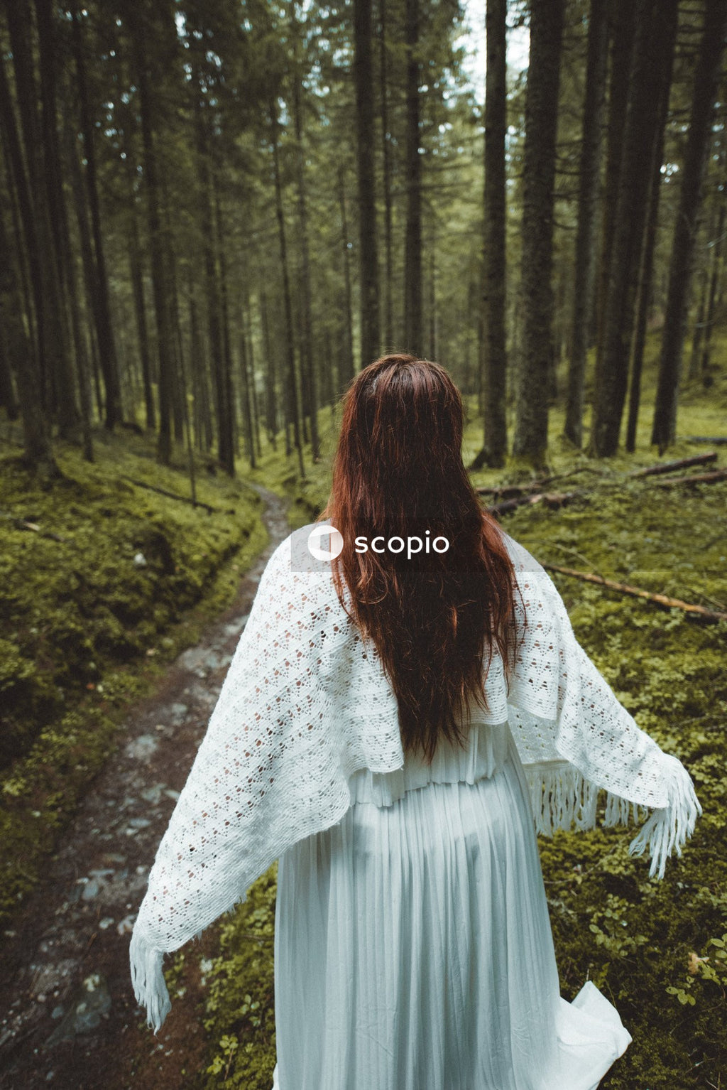 Woman in light dress walking in woods