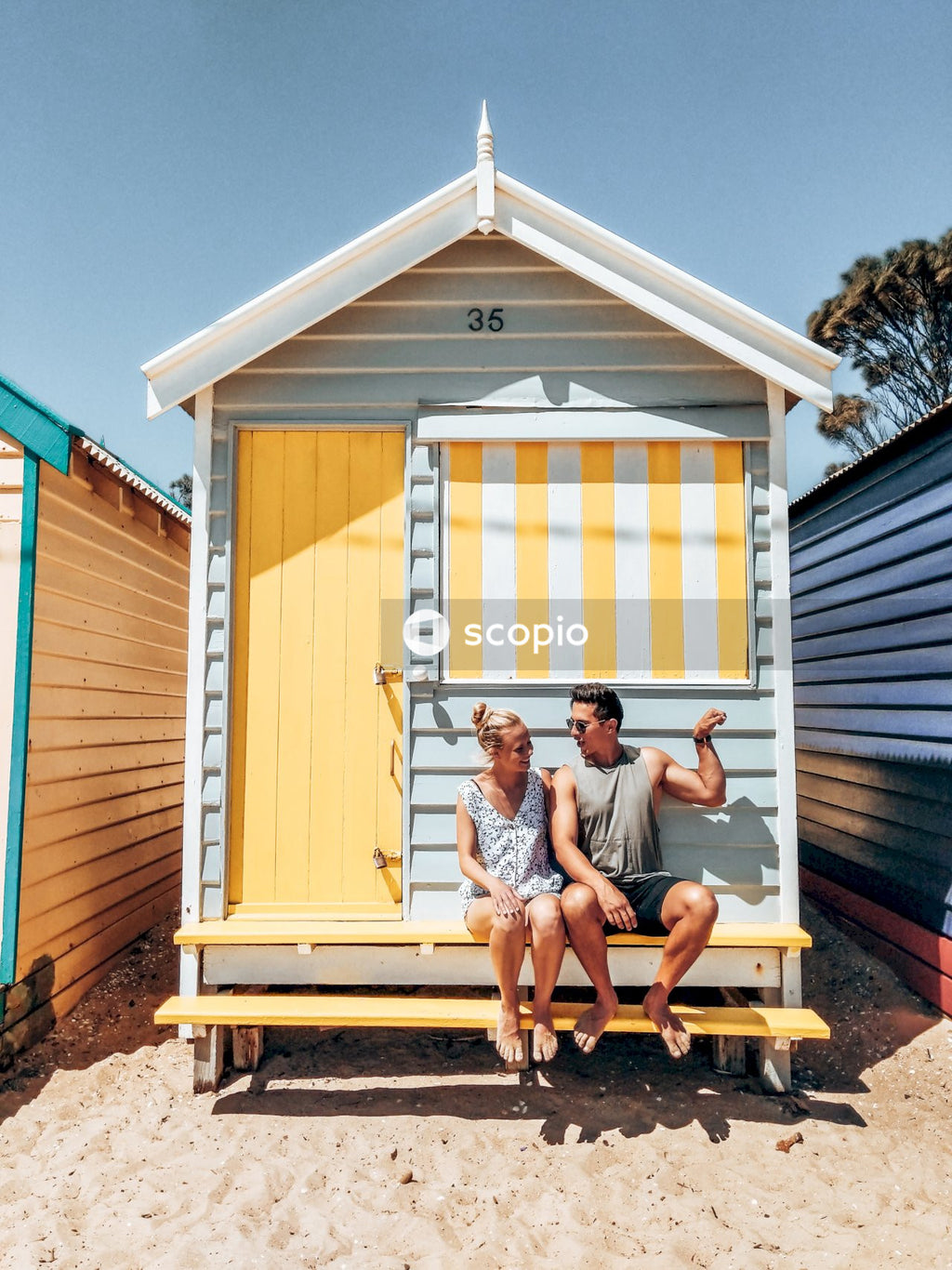 Man and woman sitting on doorstep of wooden shed