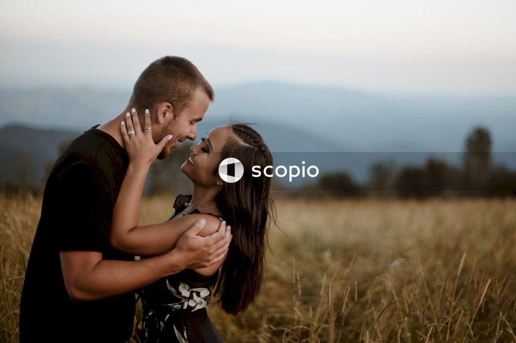 Man and woman kissing on brown grass field