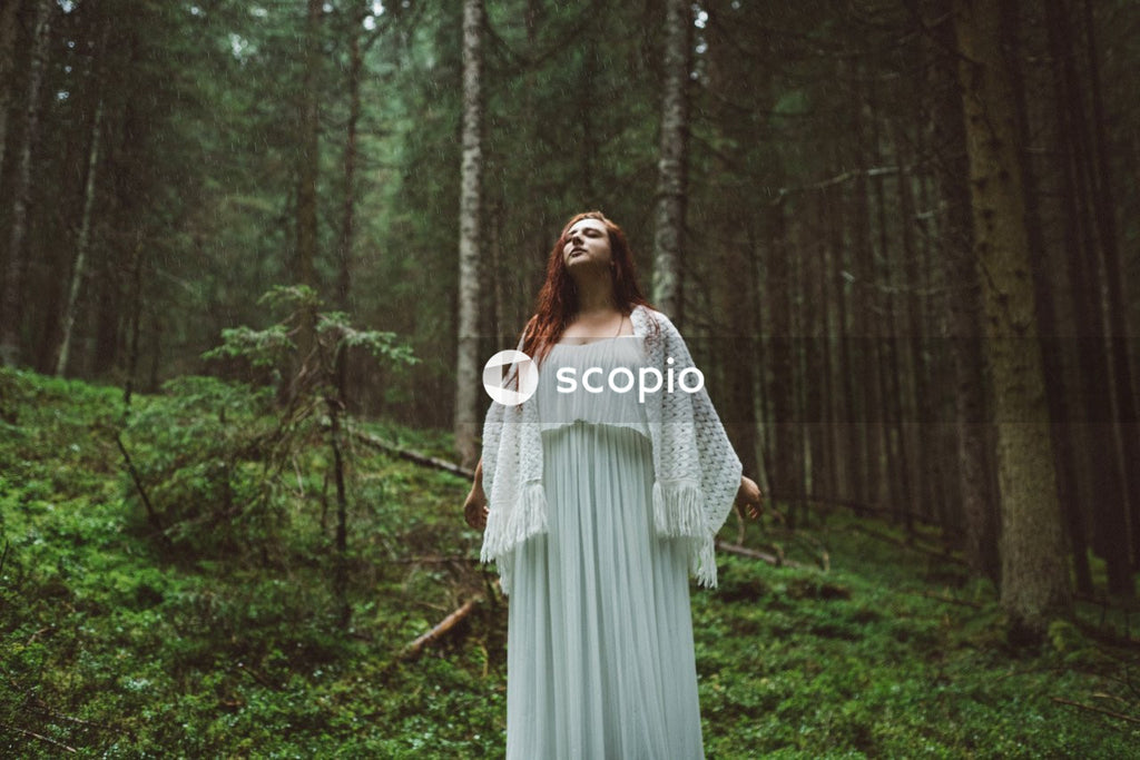 Woman wearing long dress standing on forest