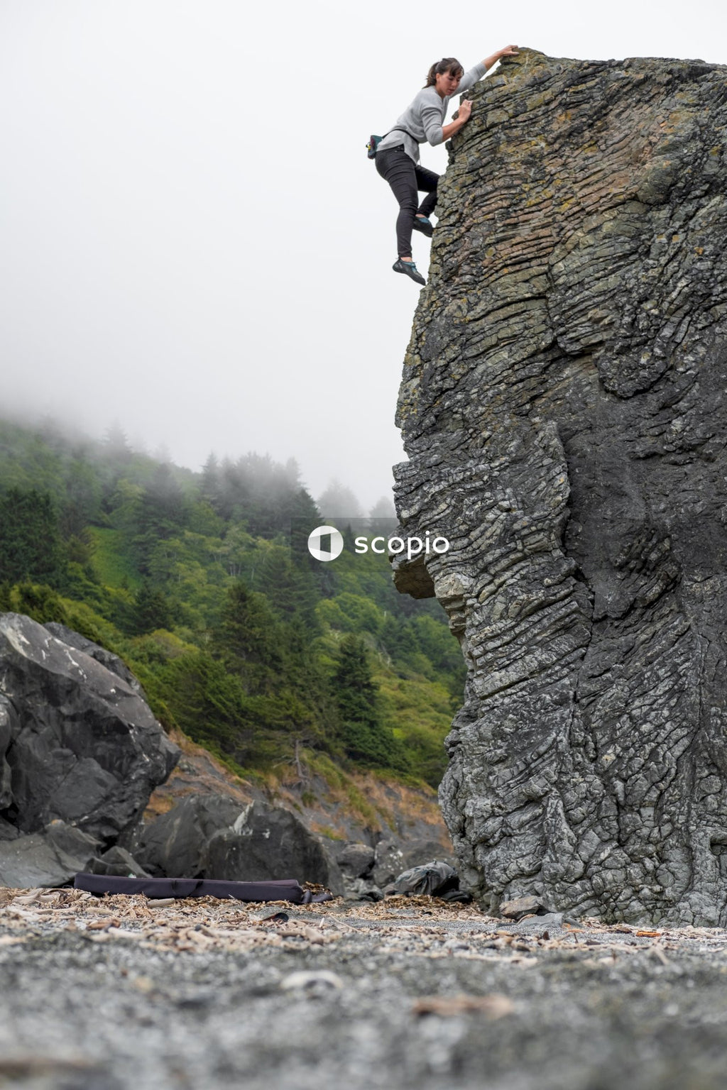 Woman climbing rocky mountain