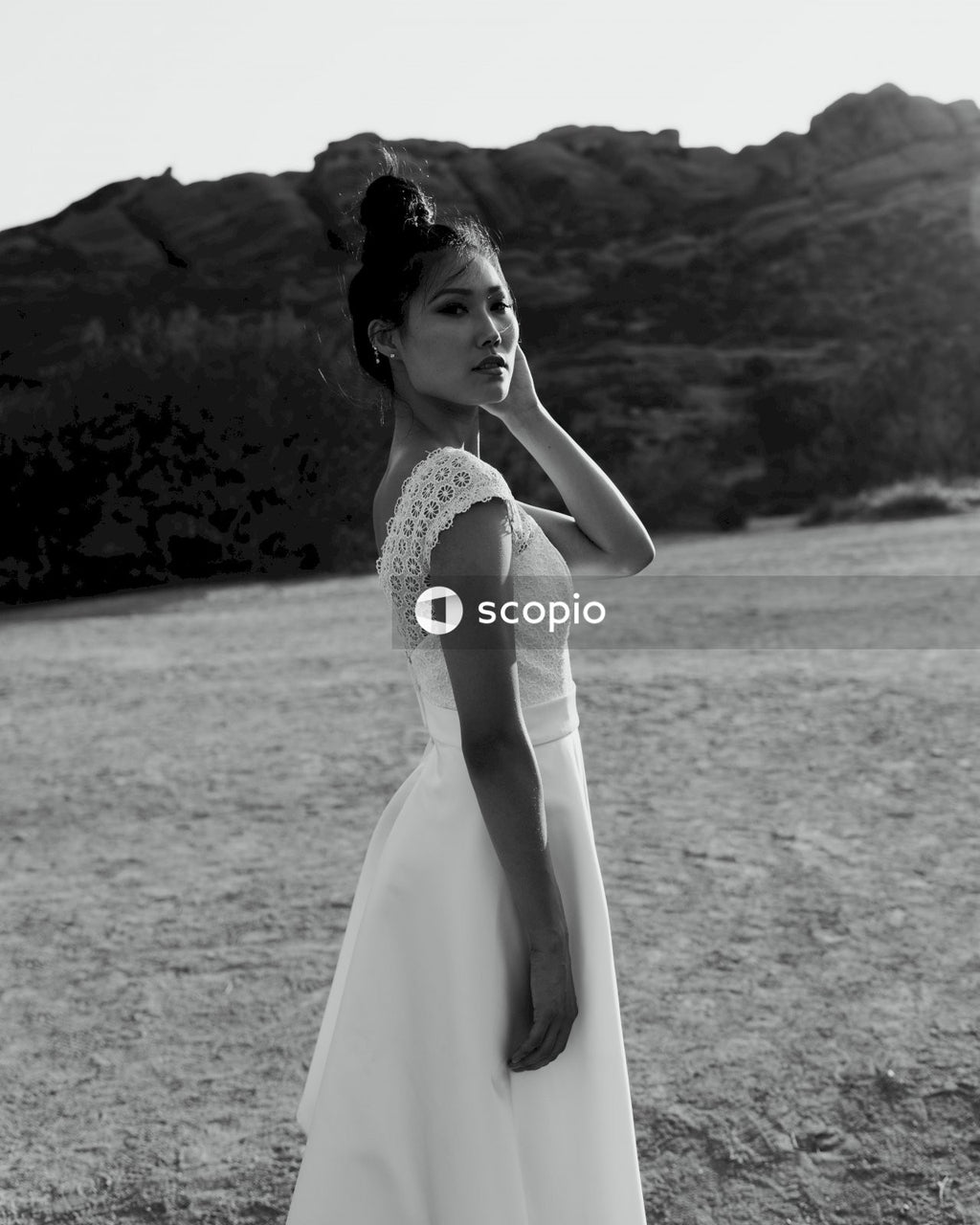 Woman in white sleeveless dress standing on field