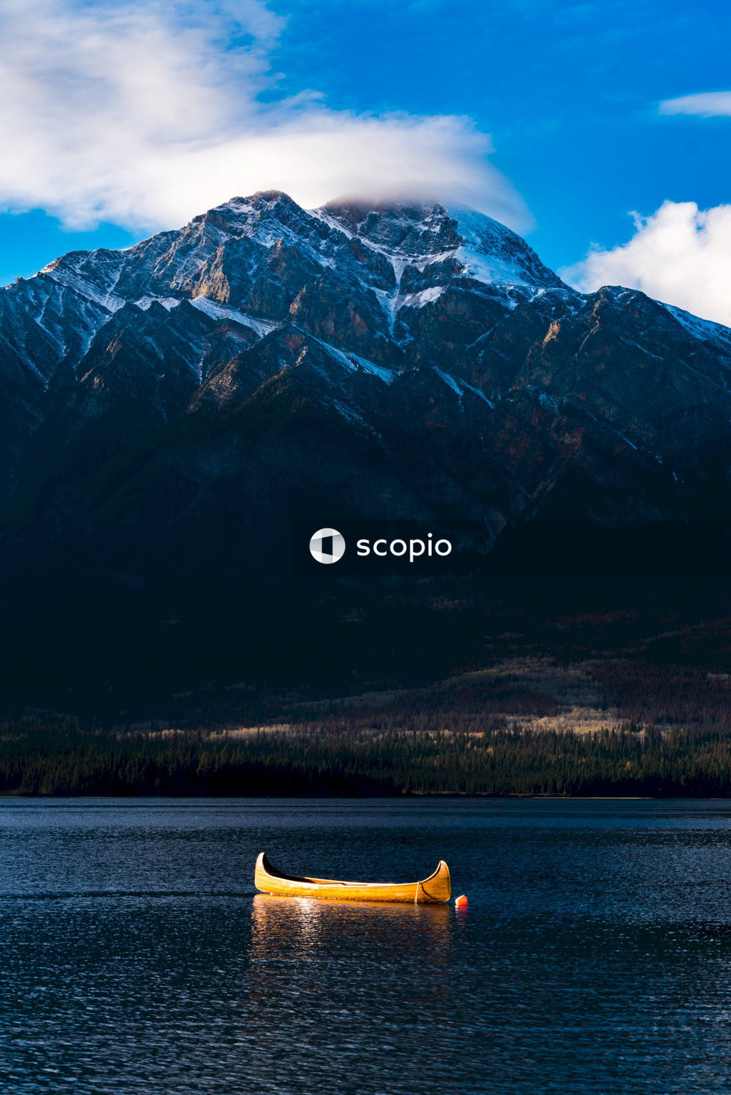 Yellow boat in lake near mountain