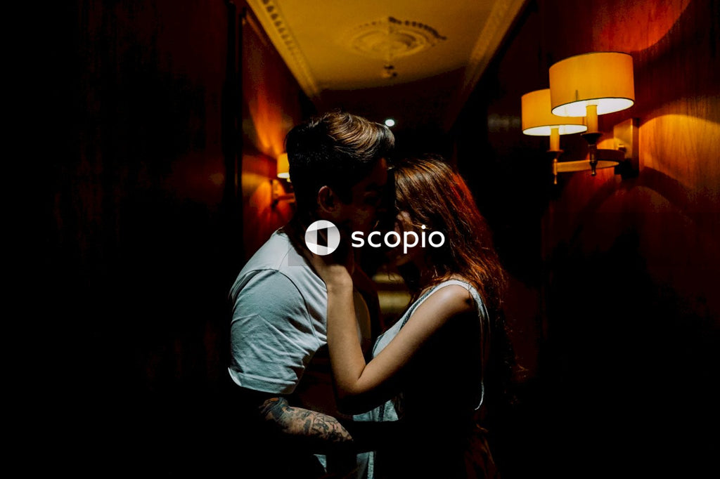 Man and woman kissing in a darkly lit hallway standing up