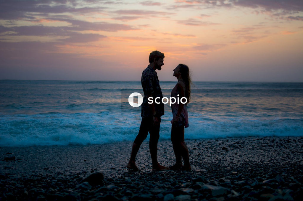 Couple standing on beach during sunset