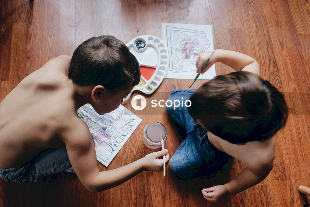 Two topless young boys coloring on the floor