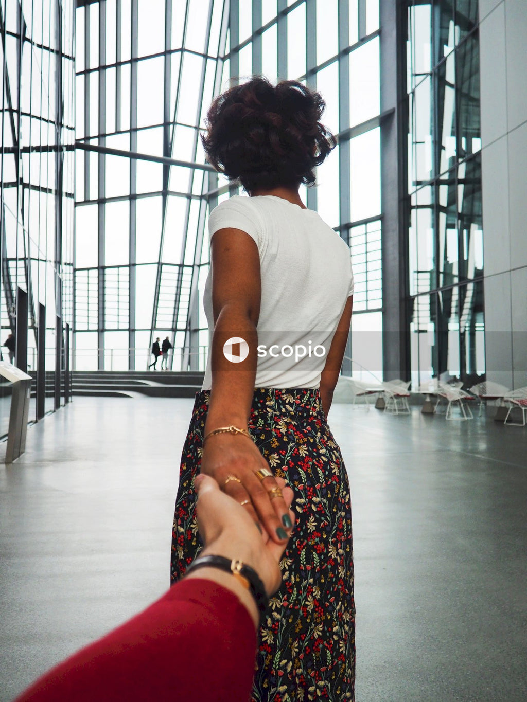 Back view of woman pulling someone's hand indoor