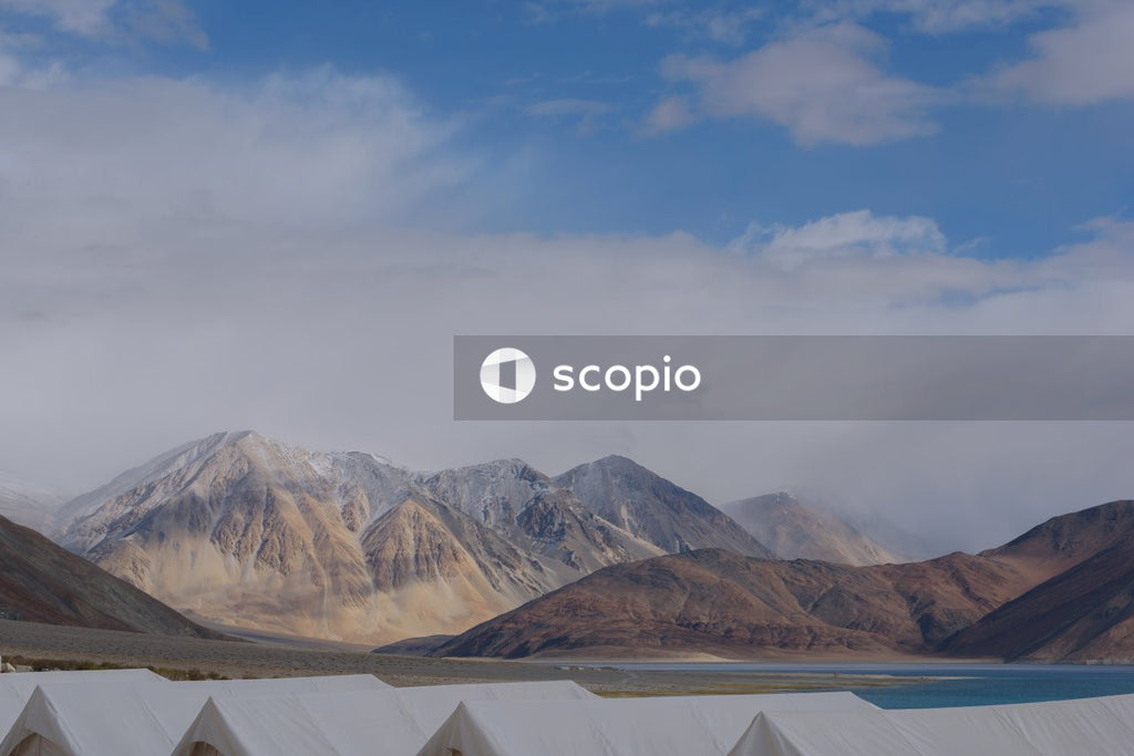 Brown and white mountains under white clouds and blue sky