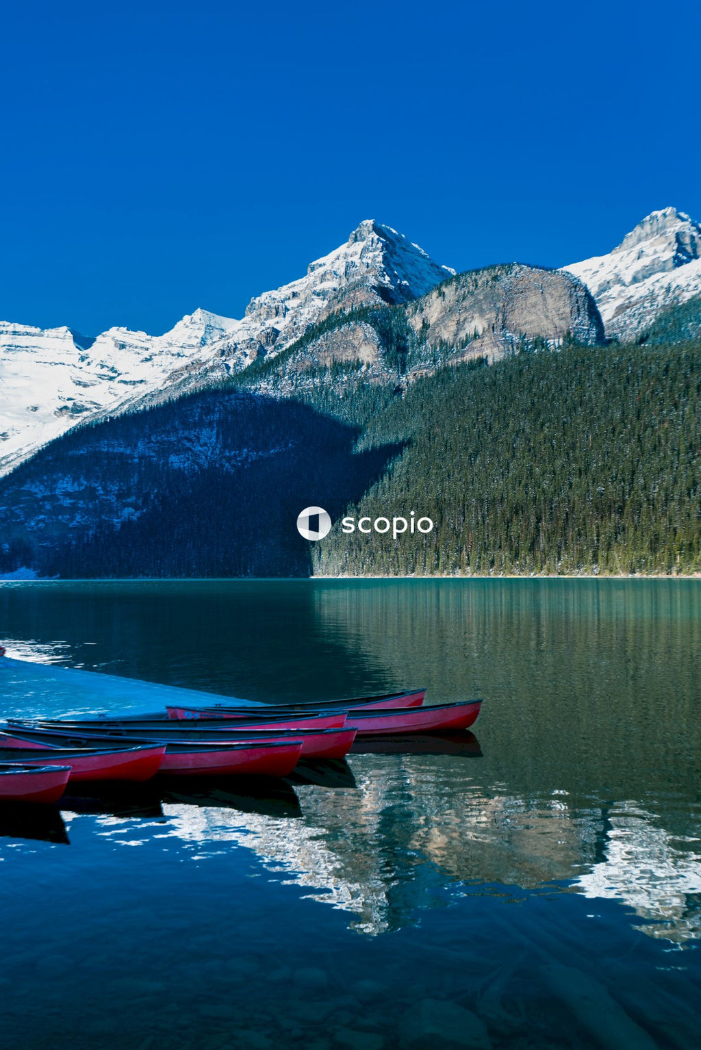 Red Kayaks on lake near snow covered mountain