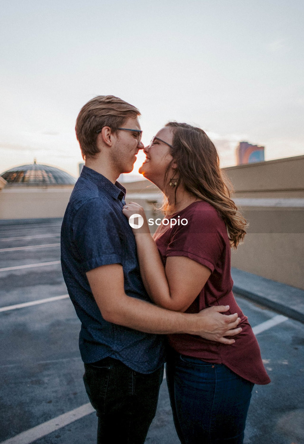 Man in blue denim jeans kissing woman in red tank top