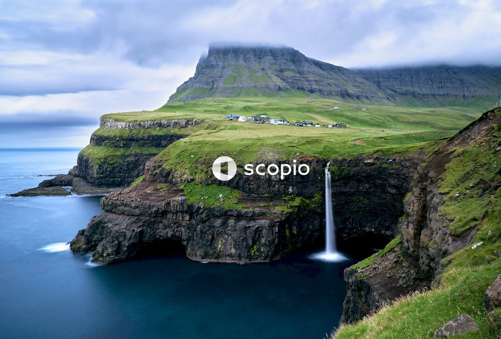 Waterfalls in front of calm body of water