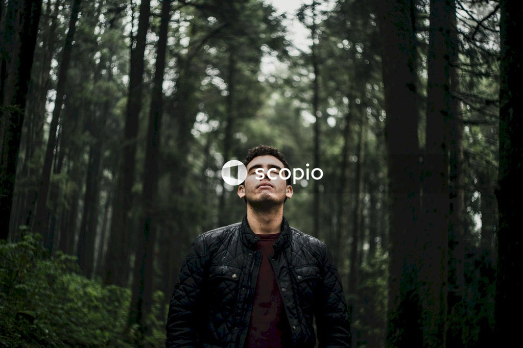 Man in black leather jacket standing in forest