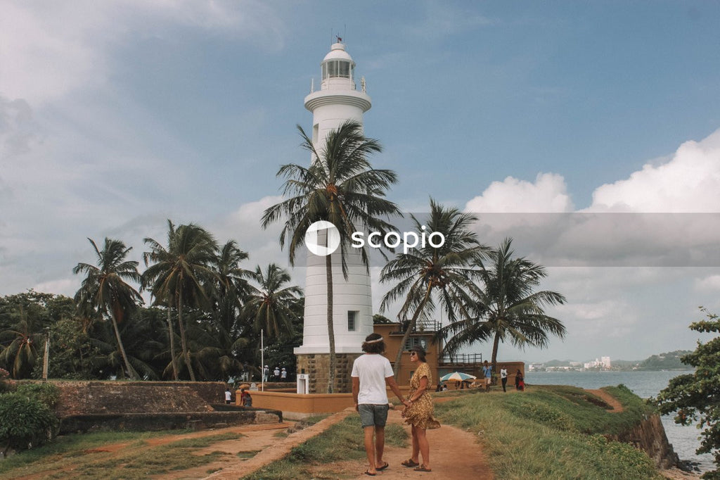 Man and woman standing near lighthouse on beach in Galle Dutch Fort in Sri Lanka