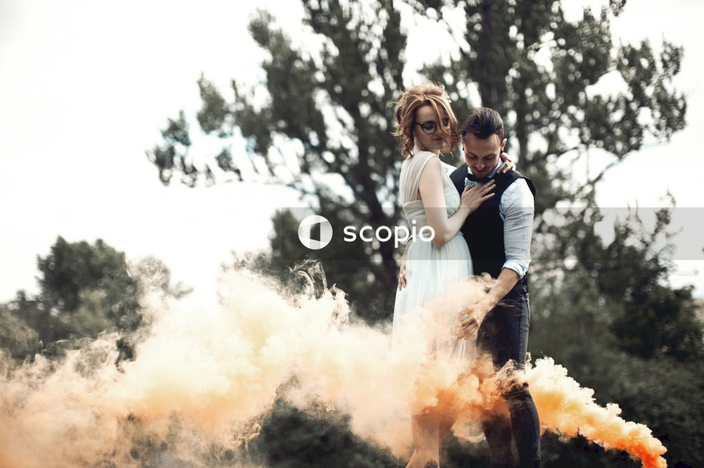 Bride and groom hugging near orange smoke