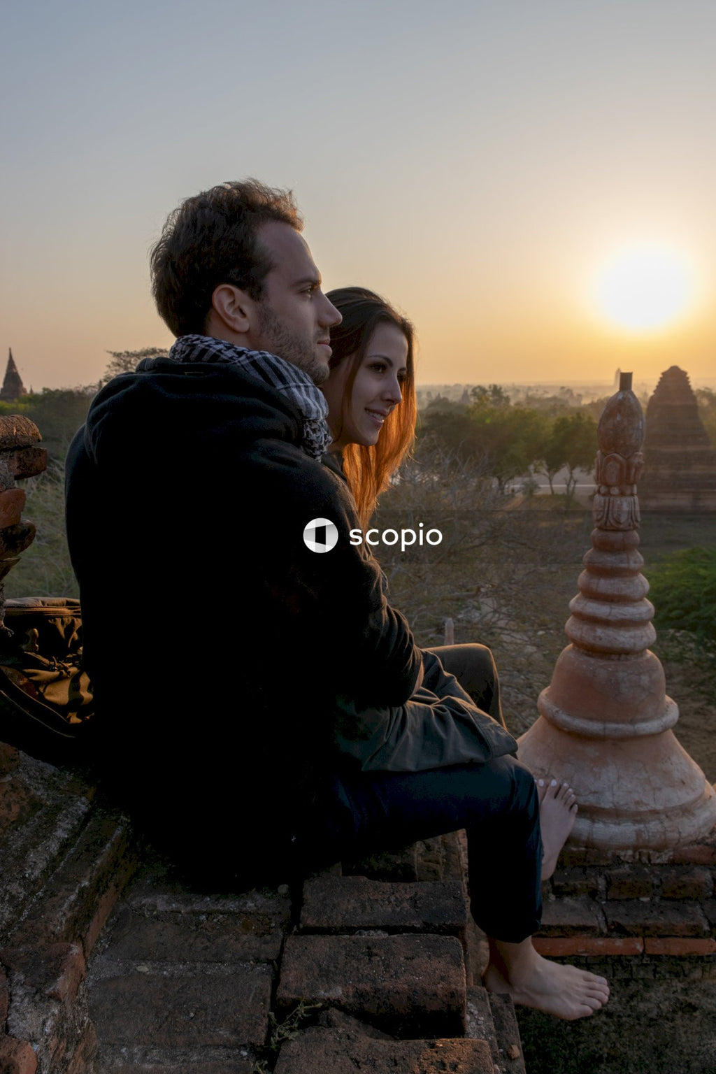 Man and woman sitting on brown concrete bench