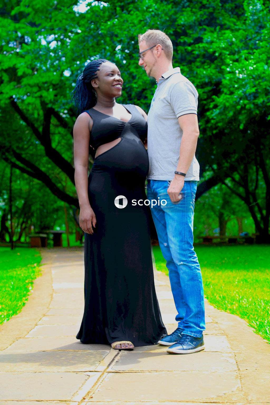 Man in white dress shirt and woman in black dress standing on pathway