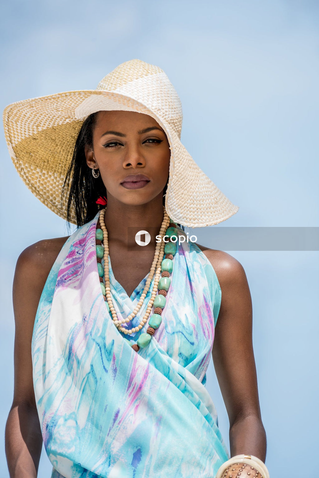 Woman in blue top and sun hat standing outdoor