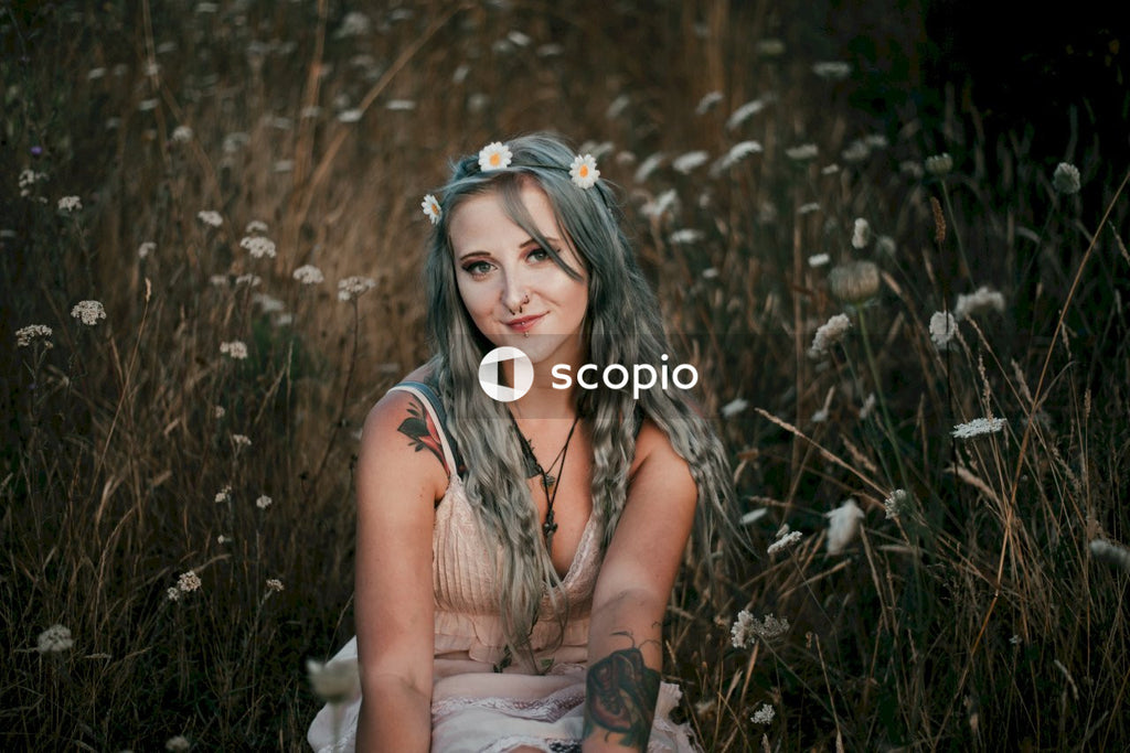 Woman in brown sleeveless dress sitting on grass