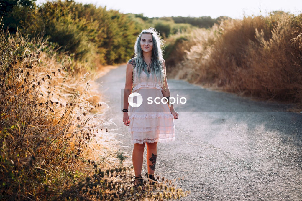 Woman in white and pink dress standing on road