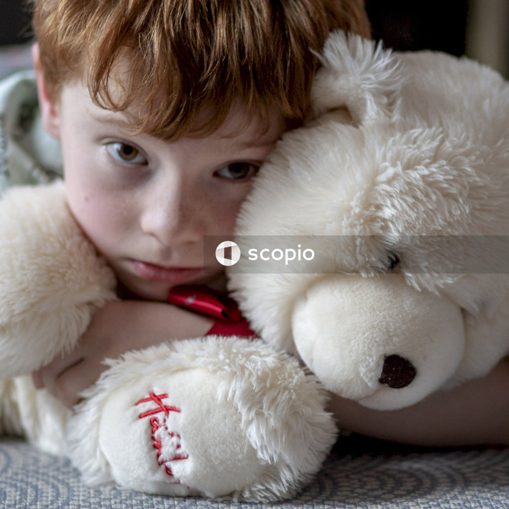 Girl hugging white teddy bear