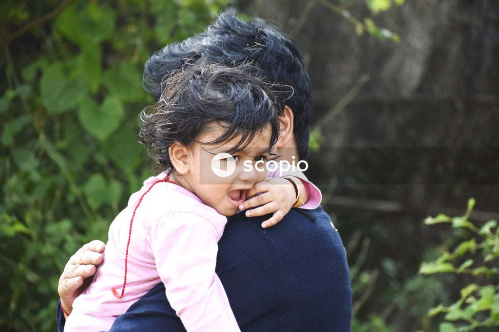 Girl in pink and white long sleeve shirt hugging woman in blue long sleeve shirt