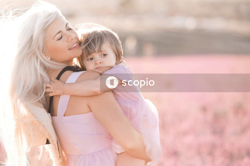 Girl in pink dress hugging girl in white dress