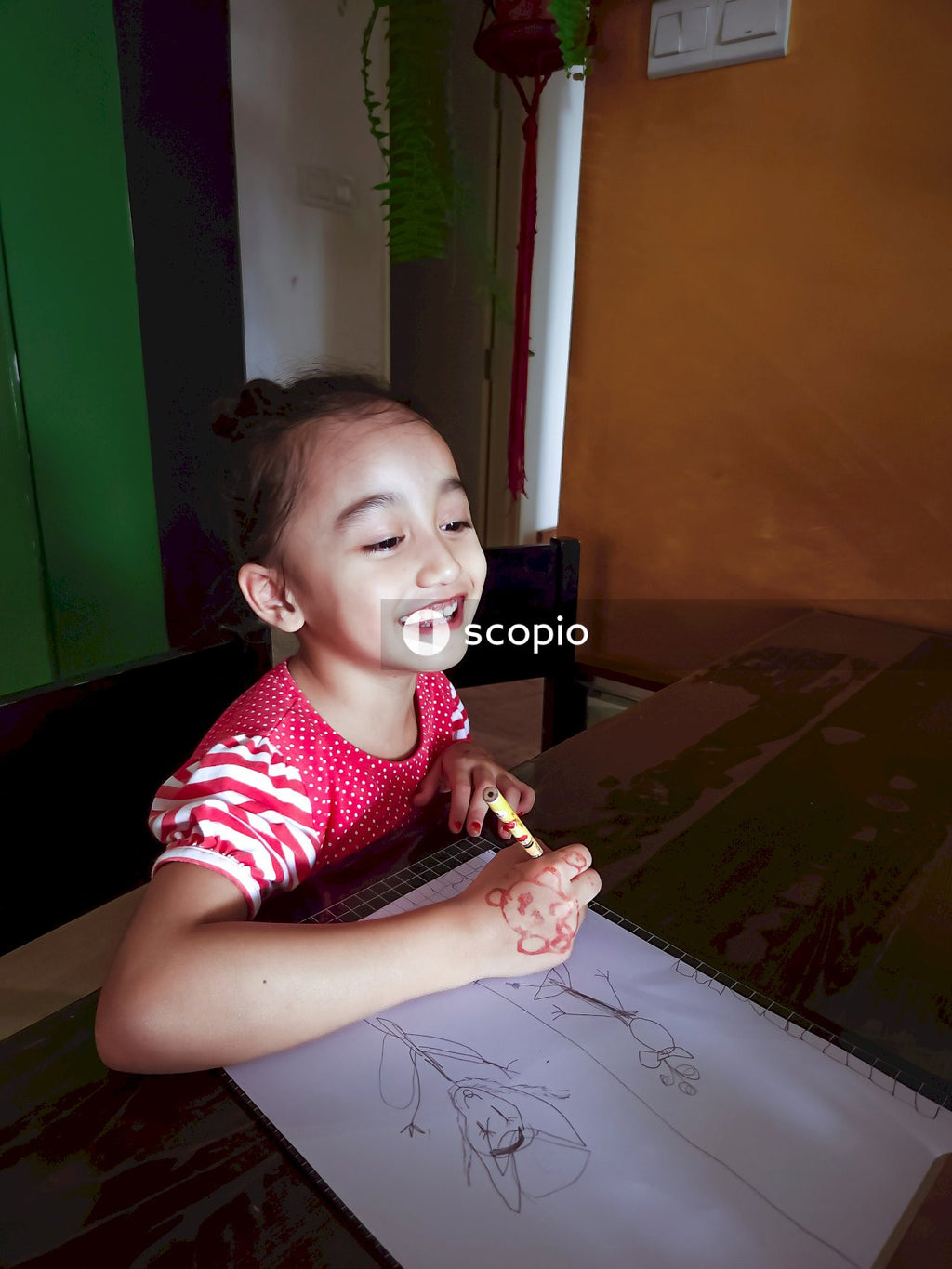 Girl in red and white polka dot shirt sitting on chair