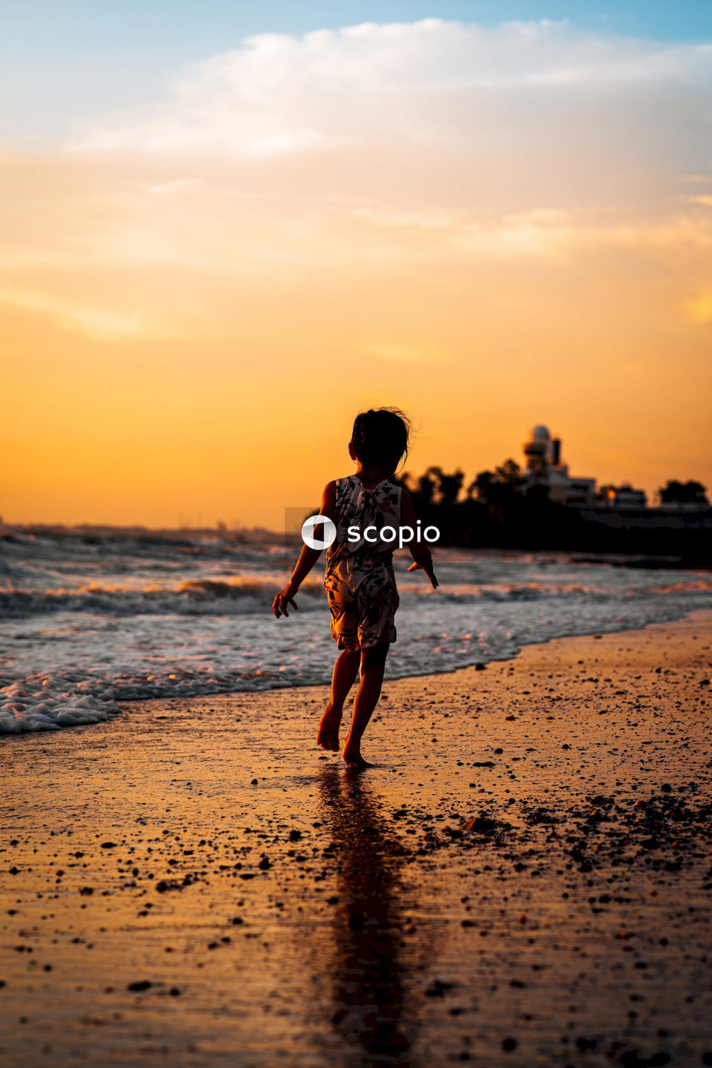 Girl in white and black dress walking on beach during sunset