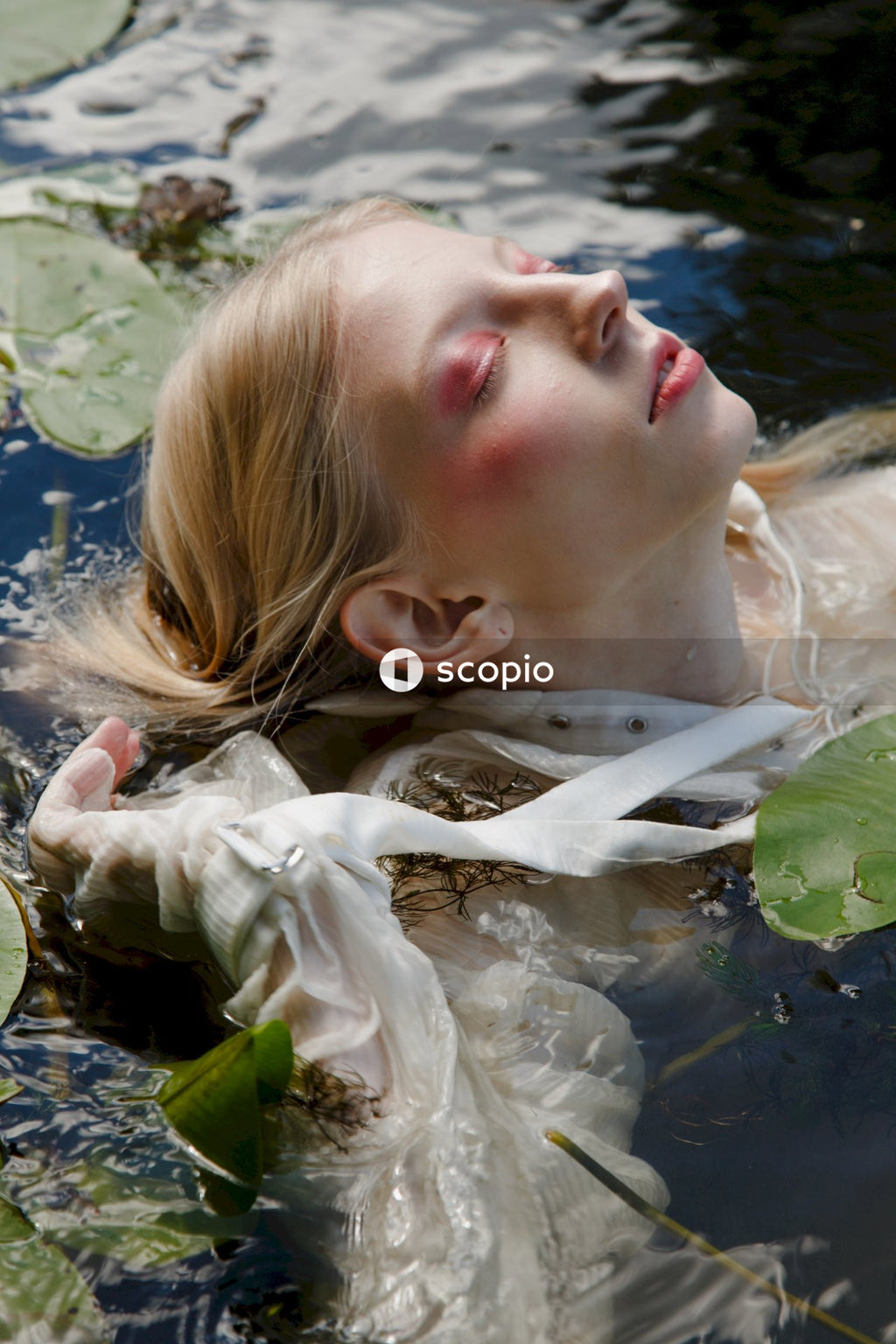 Girl in white dress lying on water