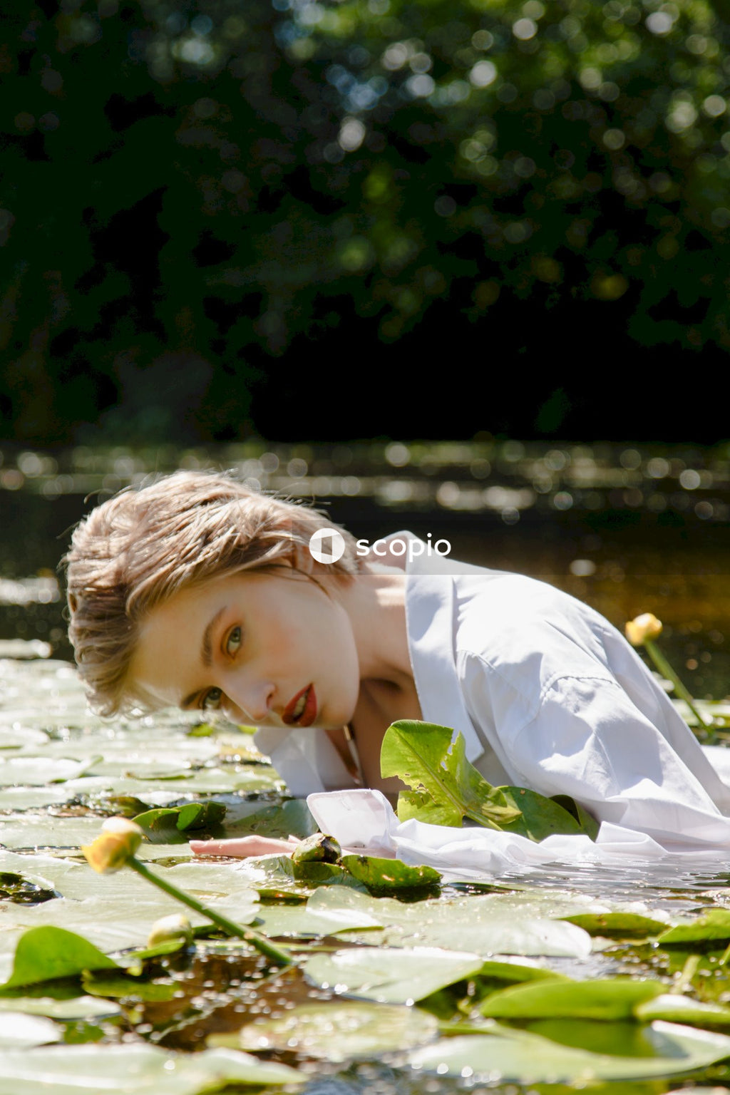 Girl in white dress lying on white textile
