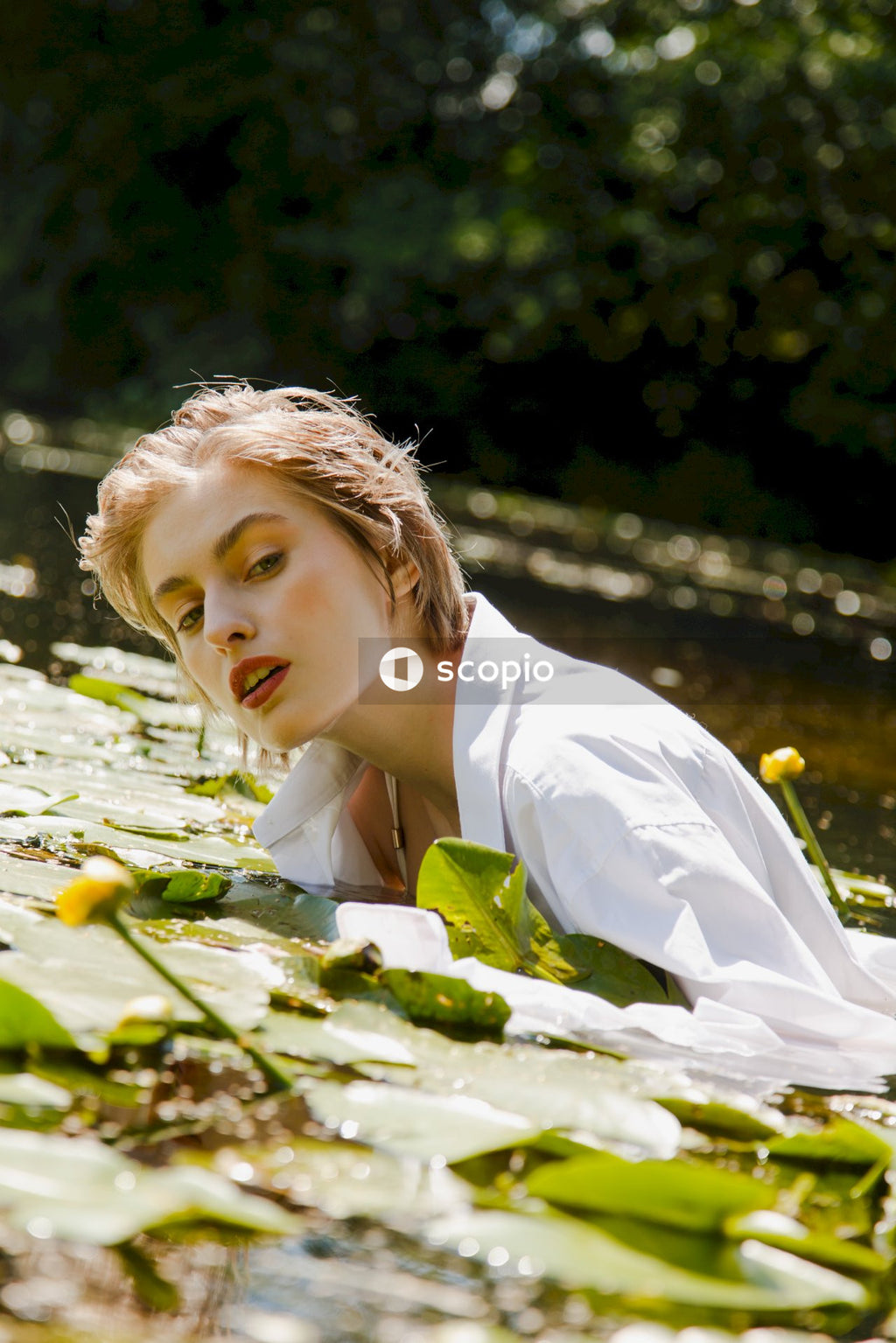 Girl in white dress shirt holding white flower