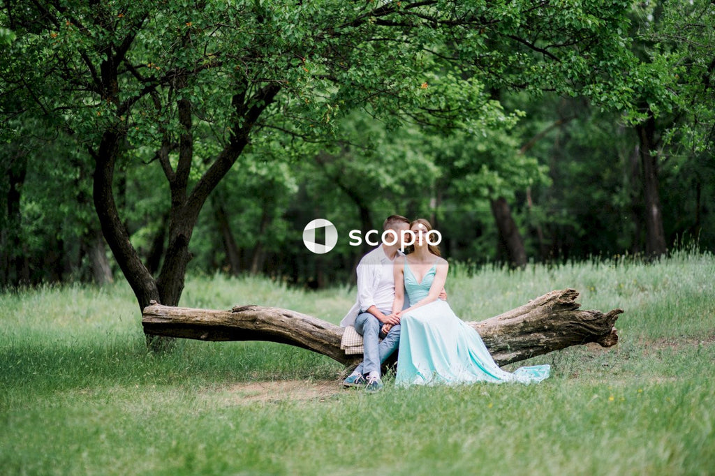 Man and woman hugging and sitting on tree log