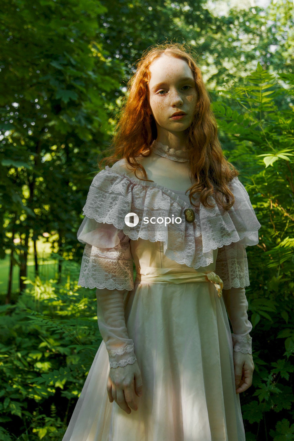 Girl in white dress standing near green plant