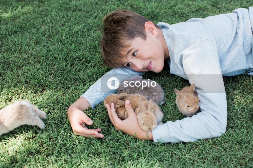 Girl in white long sleeve shirt hugging brown rabbit plush toy