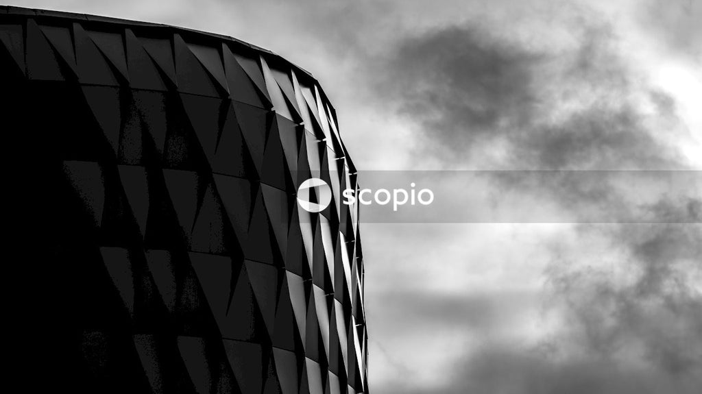Grayscale photo of building under cloudy sky