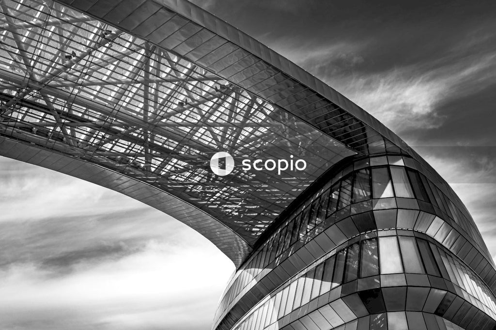 Grayscale photo of building under cloudy sky