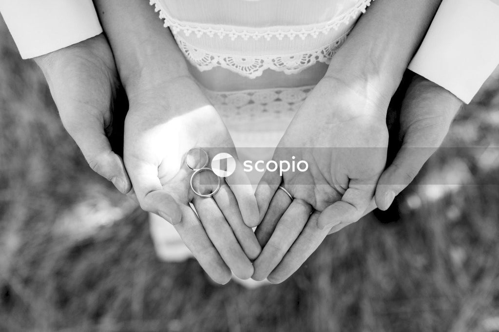Grayscale photo of couple holding hands