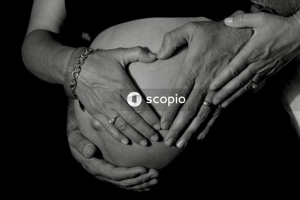 Grayscale photo of couple holding their hands