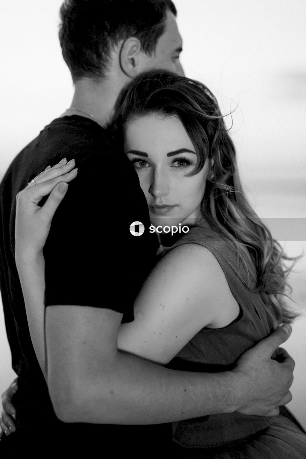 Grayscale photo of couple hugging