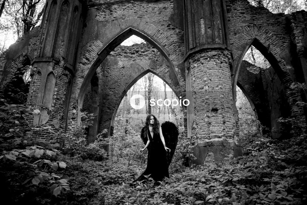 Grayscale photo of couple standing in front of brick building