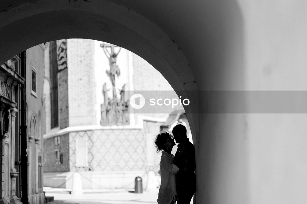 Grayscale photo of couple standing near gate