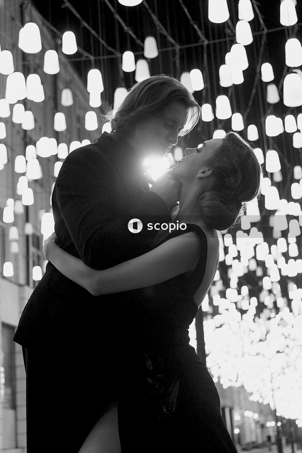 Grayscale photo of man and woman about to kiss outdoor